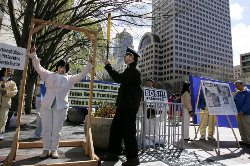 Ling Chen of San Jose, California (R) and Mary Chong of Vancouver, Canada stage a scene of torture during a protest by Falun Gong in downtown Seattle in anticipation of a visit by Chinese President Hu Jintao April 17 2006 in Seattle Washington. Hu is making his first official visit to the U.S. as president. (Photo by Robert Sumner/Getty Images)