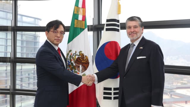 El embajador de México ante Corea del Sur, Carlos Peñafiel Soto (d), estrecha la mano del viceministro de Comercio surcoreano, Park Jung-sung, durante su reunión en la Embajada mexicana en Seúl, celebrada este viernes. (EFE/Ministerio de Comercio de Corea del Sur)