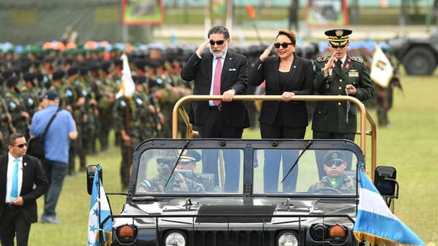 La presidenta de Honduras, Xiomara Castro, el viceministro de la Secretaría de la Defensa Nacional, Orlando Garner (izq.), y el jefe de las Fuerzas Armadas, general Roosevelt Hernández (der.), pasan revista a las tropas durante la celebración del bicentenario del Ejército hondureño en Tegucigalpa el 11 de diciembre de 2025. El ejército hondureño se comprometió el miércoles a garantizar una transferencia pacífica del poder, independientemente del ganador de las elecciones presidenciales del 30 de noviembre, en las que aún se están contando los votos en medio de acusaciones de interferencia. (Foto de Orlando SIERRA / AFP vía Getty Images)