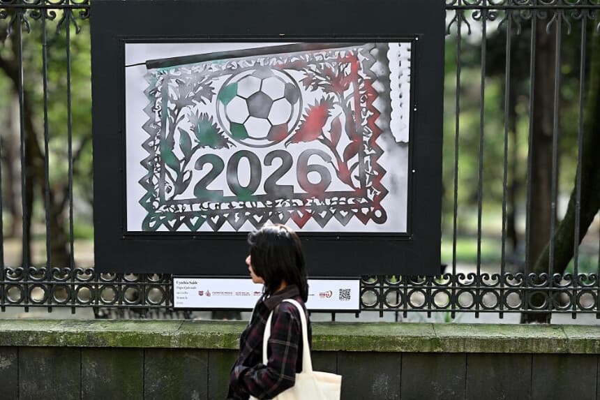 Una mujer pasa junto a unas acuarelas de Cynthia Saide con motivos de la Copa Mundial de la FIFA 2026 en el parque Chapultepec de Ciudad de México, el 5 de diciembre de 2025. (Yuri CORTEZ / AFP a través de Getty Images)