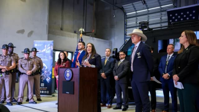 Madison Sheahan (centro), subdirectora del Servicio de Inmigración y Control de Aduanas (ICE), y Mark Glass (al frente, 2.º por la derecha), comisionado del Departamento de Aplicación de la Ley de Florida, ofrecen una conferencia de prensa en el edificio de Operaciones de Deportación y Control de Aduanas del ICE en Miramar, Florida, el 13 de noviembre de 2025. (Joe Raedle/Getty Images)