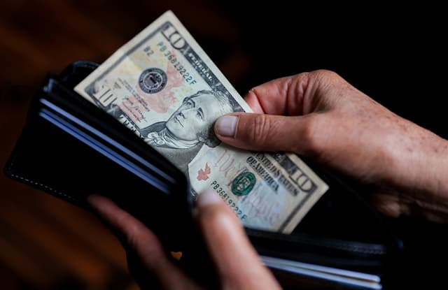 Una persona sostiene un billete de 10 dolares. Imagen de archivo. (EFE/ José Jácome)