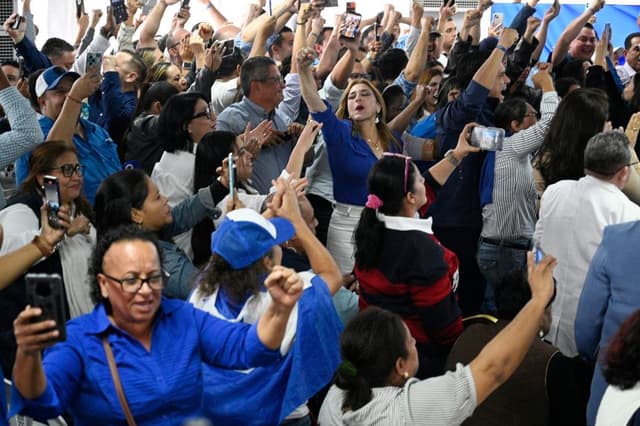 Los partidarios del candidato presidencial hondureño Nasry Asfura, del Partido Nacional, celebran después de que el Consejo Nacional Electoral (CNE) lo declare ganador de las elecciones presidenciales en Tegucigalpa el 24 de diciembre de 2025. (Orlando SIERRA / AFP a través de Getty Images)