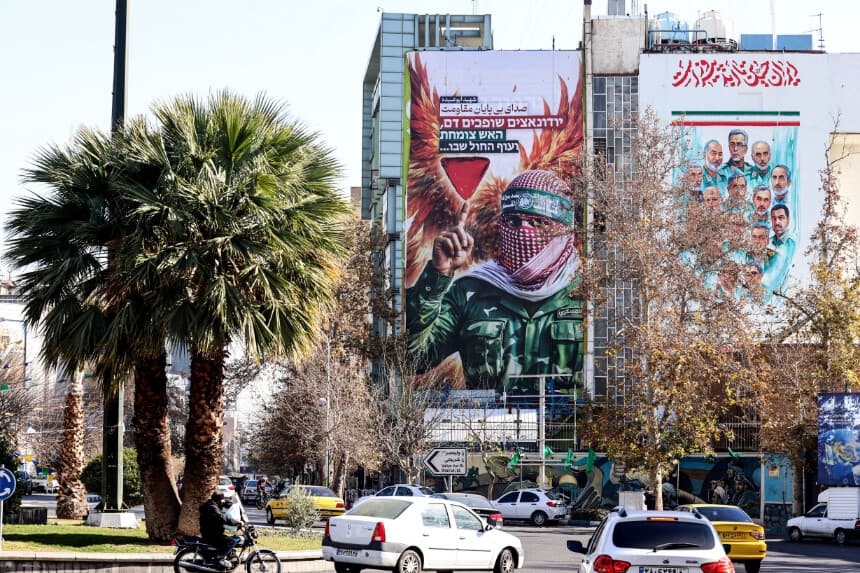 El 31 de diciembre de 2025, se coloca en la plaza Palestina de Teherán una gran pancarta antiisraelí con la imagen de un combatiente palestino y el lema "Voz infinita de la resistencia" en persa y hebreo. La agencia de espionaje israelí Mossad hizo un llamamiento directo el 31 de diciembre de 2025, instando a los iraníes a continuar con las protestas y afirmando que los apoyaba "sobre el terreno", mientras las manifestaciones se extendían por la capital, Teherán, y otras ciudades iraníes. Las protestas comenzaron el 28 de diciembre de 2025, cuando los comerciantes de Teherán se manifestaron contra el empeoramiento de la economía iraní, y se extendieron a otras ciudades, atrayendo también a los estudiantes. (Foto de ATTA KENARE / AFP a través de Getty Images).