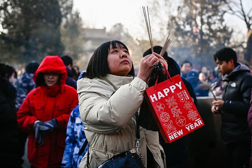 Una mujer quema varitas de incienso y reza en el templo Yonghe, también conocido como templo Lama, el primer día del año nuevo en Beijing, el 1 de enero de 2026. (WANG Zhao / AFP a través de Getty Images)