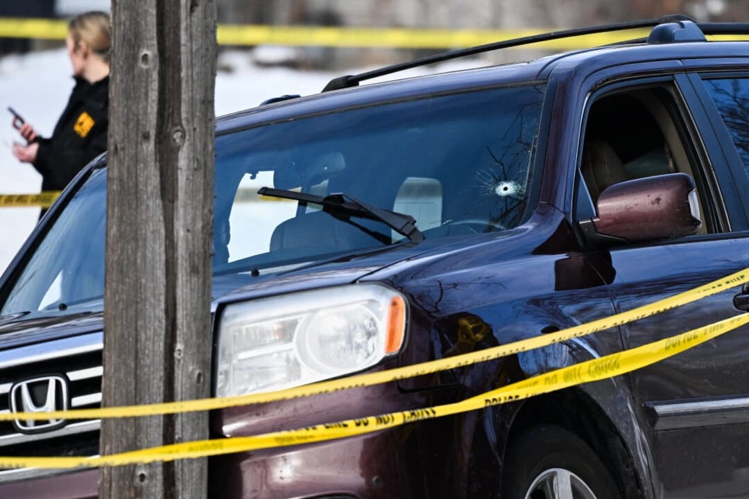 Se ve un agujero de bala en el parabrisas mientras agentes de la ley trabajan en la escena de un tiroteo que involucró a agentes federales en Minneapolis el 7 de enero de 2026. (Tom Baker/AP Photo)