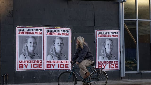 Un ciclista pasa junto a carteles de Renee Good el 12 de enero de 2026 en Minneapolis, Minnesota. (Scott Olson/Getty Images)