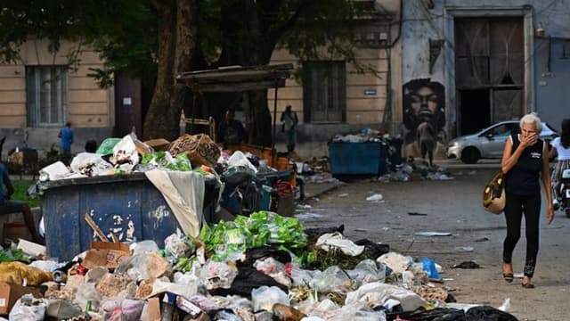 Una mujer se tapa la nariz al pasar junto a la basura en una calle de La Habana el 4 de diciembre de 2025. Veintiún niños se encuentran entre las 33 personas que han fallecido en Cuba a causa de los virus del chikunguña y el dengue, transmitidos por mosquitos, desde julio, según informaron las autoridades el lunes. (YAMIL LAGE/AFP a través de Getty Images)