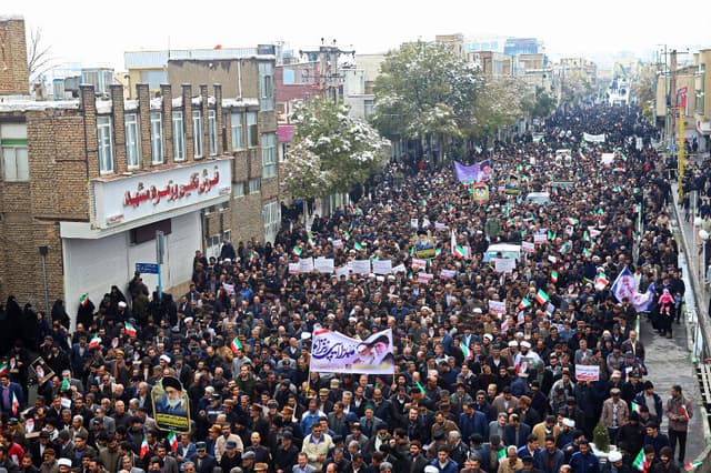 Los iraníes salen a las calles en apoyo al Gobierno de la República Islámica y al líder supremo, el ayatolá Alí Jamenei, en la ciudad central de Arak, al suroeste de la capital, Teherán, el 20 de noviembre de 2019, mientras el presidente Hassan Rouhani afirmaba que el pueblo del país había derrotado una “conspiración enemiga” detrás de una ola de violentas protestas callejeras. Las manifestaciones estallaron en Irán, país afectado por las sanciones, la semana pasada tras el anuncio de que el precio de la gasolina se incrementaría hasta un 200 %, lo que provocó que los automovilistas bloquearan las principales carreteras de Teherán antes de que los disturbios se extendieran rápidamente a al menos 40 centros urbanos, con surtidores de gasolina incendiados, comisarías de policía atacadas y tiendas saqueadas. (Foto de STR / AFP) (Foto de STR/AFP a través de Getty Images).