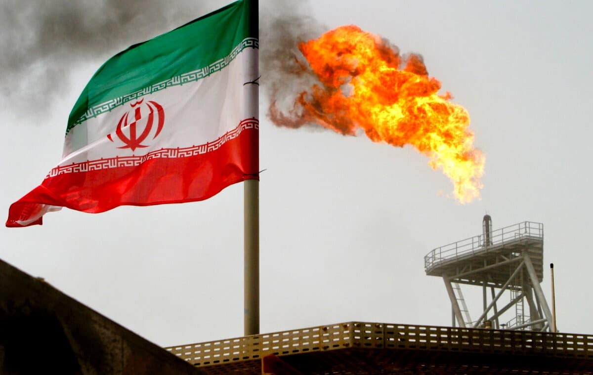 Una antorcha de gas en una plataforma petrolífera junto a una bandera iraní en el Golfo Pérsico, el 25 de julio de 2005. (Raheb Homavandi/Reuters).