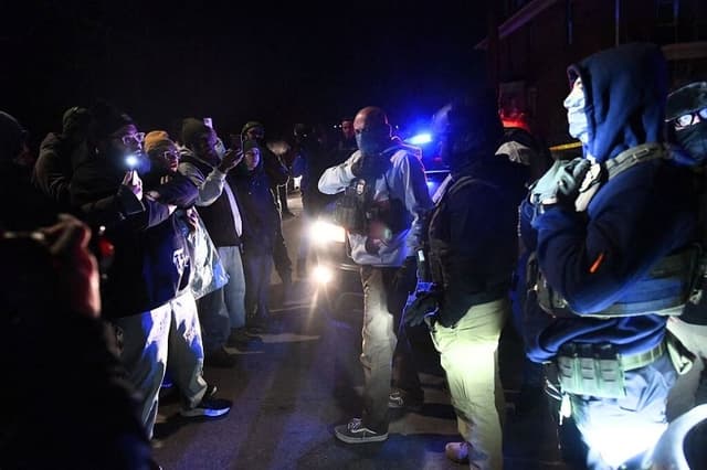 Agentes del ICE enmascarados y manifestantes se enfrentan tras las protestas que estallaron tras el tiroteo de un venezolano por parte de un agente del Servicio de Inmigración y Control de Aduanas (ICE) en Minneapolis, Minnesota, el 14 de enero de 2026. (Octavio JONES / AFP a través de Getty Images)