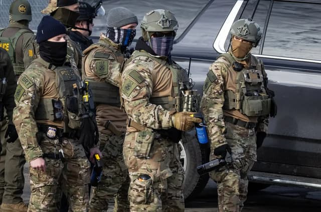 Agentes del Servicio de Inmigración y Control de Aduanas (ICE) se enfrentan a manifestantes frente al edificio federal Bishop Henry Whipple en Minneapolis, Minnesota, el 12 de enero de 2026. (John Fredricks/The Epoch Times)