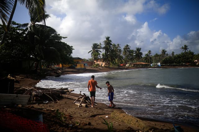 Niños migrantes venezolanos caminan en la playa este 20 de enero de 2026, en el puerto costero en Miramar, Panamá. (EFE/ Bienvenido Velasco)
