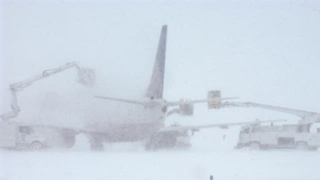 El personal encargado del deshielo intenta limpiar la nieve y el hielo de un avión de Continental Airlines en el Aeropuerto Internacional de Denver, el 20 de diciembre de 2006, en Denver, Colorado. (Thomas Cooper/Getty Images).