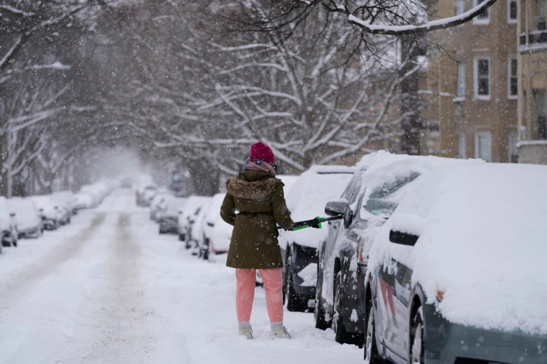 Una persona limpia la nieve de un carro durante un día nevado en Chicago, el 25 de enero de 2026. (Nam Y. Huh/AP Photo)