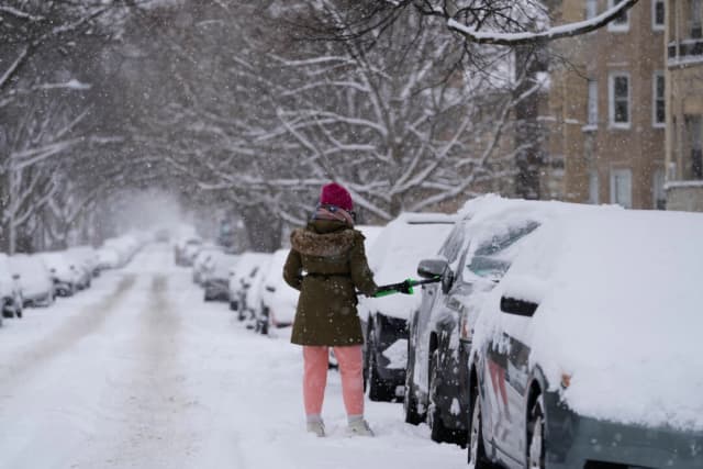 Una persona limpia la nieve de un carro durante un día nevado en Chicago, el 25 de enero de 2026. (Nam Y. Huh/AP Photo)