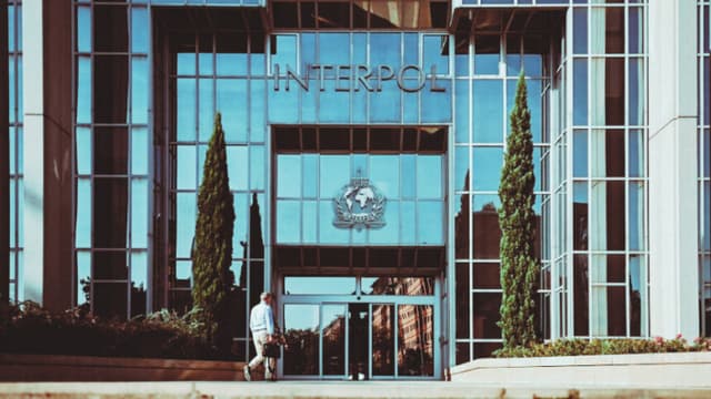 Un hombre camina hacia la entrada de la sede de la Organización Internacional de Policía Criminal, conocida como Interpol, en Lyon, al este de Francia, el 5 de septiembre de 2023. (OLIVIER CHASSIGNOLE/AFP vía Getty Images)