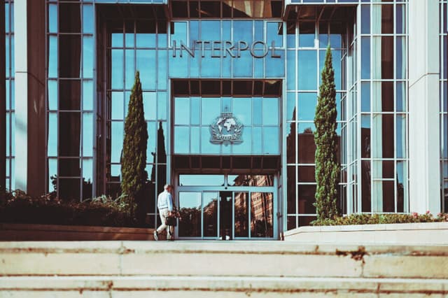 Un hombre camina hacia la entrada de la sede de la Organización Internacional de Policía Criminal, conocida como Interpol, en Lyon, al este de Francia, el 5 de septiembre de 2023. (OLIVIER CHASSIGNOLE/AFP vía Getty Images)