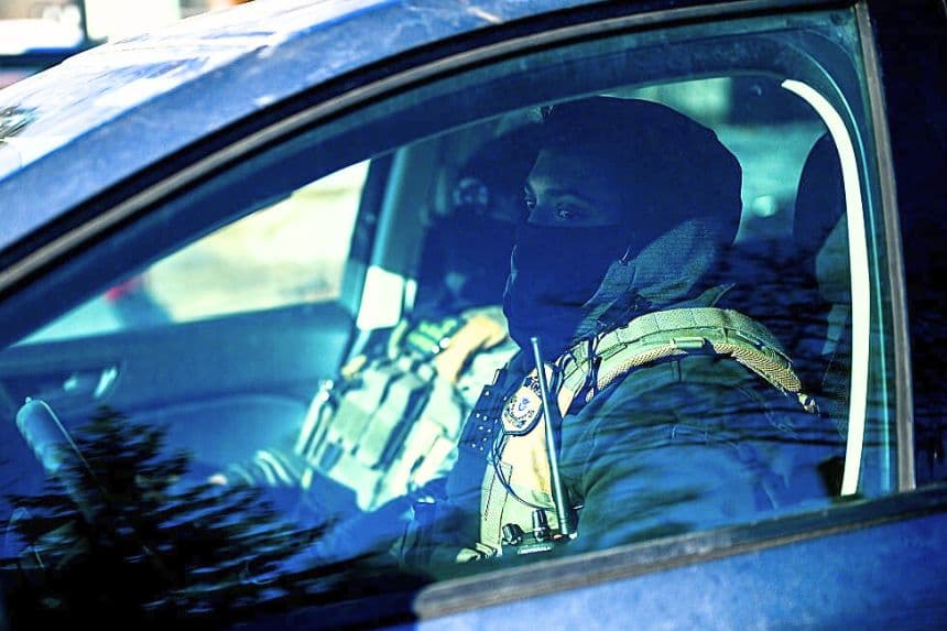 Dos agentes del ICE pasan en coche durante una vigilia en un memorial cerca del lugar donde Renee Good fue asesinada hace una semana, el 14 de enero de 2026, en Minneapolis, Minnesota. (Stephen Maturen/Getty Images)