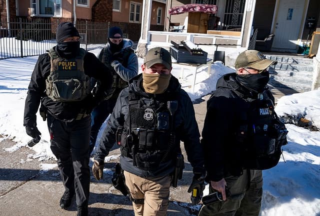 Agentes del ICE abandonan una residencia tras llamar a la puerta el 28 de enero de 2026 en Minneapolis, Minnesota. (Stephen Maturen/Getty Images)