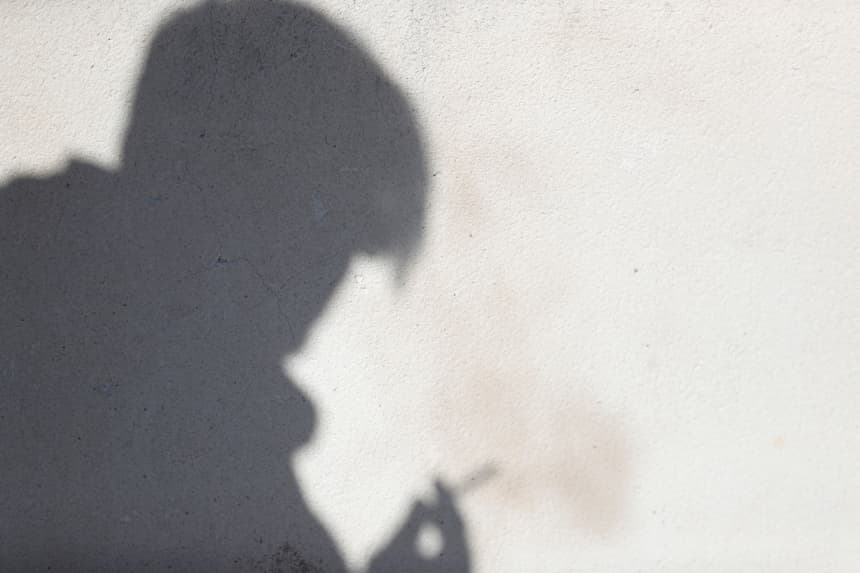 Fotografía de archivo que muestra la silueta de una persona sosteniendo un cigarrillo en Ciudad de México (EFE/Javier Lizón)