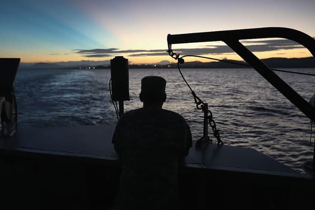 Un soldado estadounidense contempla los primeros rayos de sol mientras se encuentra en un ferry al amanecer cerca de la prisión militar conocida como "Gitmo", el 24 de octubre de 2016 en la base naval estadounidense de la Bahía de Guantánamo, Cuba. (John Moore/Getty Images)