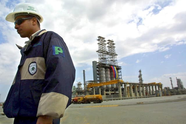 Un trabajador de Petrozuata camina por el lugar el 13 de febrero de 2001, durante la visita del presidente Hugo Chávez al complejo en el estado Anzoátegui, Venezuela. (JUAN BARRETO/AFP via Getty Images)