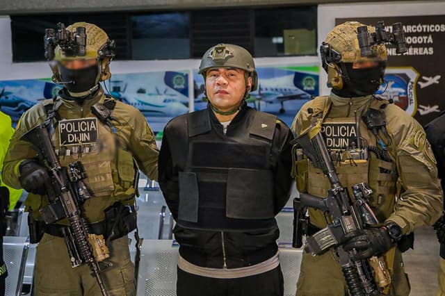 Fotografía cedida por la Policía Nacional de Colombia que muestra integrantes de la Dirección de Investigación Criminal e INTERPOL (DIJIN), custodiando al colombiano Andrés Felipe Marín Silva (c), alias Pipe Tuluá, durante su proceso de extradición a los Estados Unidos este martes, en Bogotá, Colombia. (EFE/ Policía Nacional de Colombia)