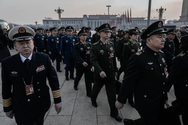 Los delegados militares caminan en fila al llegar a la sesión inaugural de la Asamblea Popular Nacional, o NPC, en el Gran Salón del Pueblo en Beijing, China, el 5 de marzo de 2025. (Kevin Frayer/Getty Images)