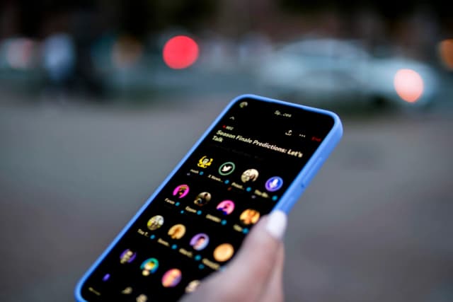 Una mujer sostiene un teléfono en el que se ve la aplicación X, en esta foto de archivo, el 11 de agosto de 2024. (Oleksii Pydsosonnii/The Epoch Times)