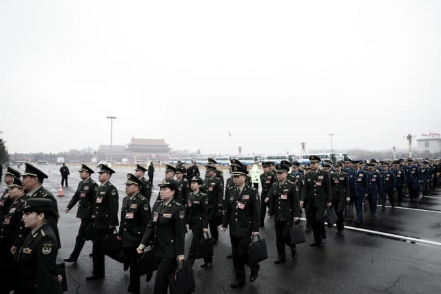 Delegados militares llegan a la sesión inaugural de la Asamblea Popular Nacional en el Gran Salón del Pueblo en Pekín el 5 de marzo de 2024. Según fuentes internas, el incumplimiento pasivo ha comenzado a extenderse desde el Ejército Popular de Liberación al sistema administrativo civil, lo que complica la capacidad de Pekín para hacer cumplir las directivas clave emitidas por el líder del PCCh, Xi Jinping. (Lintao Zhang/Getty Images)