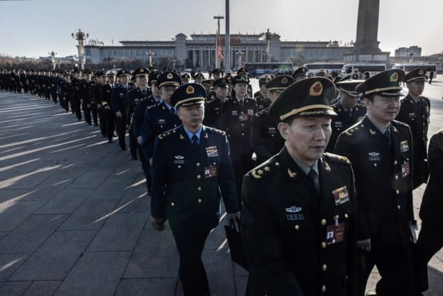 Delegados militares chinos llegan a la segunda sesión plenaria de la legislatura de China en el Gran Salón del Pueblo en Beijing el 8 de marzo de 2024. (Kevin Frayer/Getty Images)