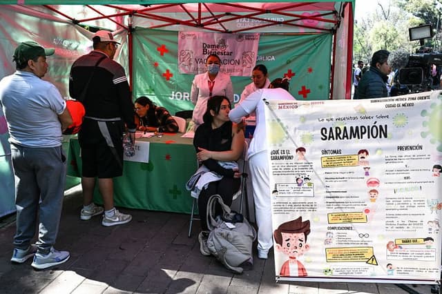 Una mujer recibe una dosis de la vacuna contra el sarampión en un módulo sanitario del bosque de Chapultepec durante una campaña de vacunación masiva puesta en marcha por la Secretaría de Salud debido al aumento de los casos de sarampión en la Ciudad de México, el 8 de febrero de 2026. (Yuri CORTEZ/AFP vía Getty Images)