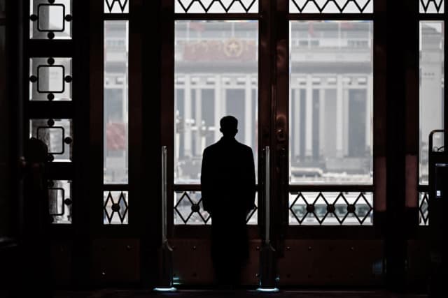 Un guardia de seguridad permanece en su puesto durante la sesión inaugural de la legislatura china, la Asamblea Popular Nacional, en el Gran Salón del Pueblo en Beijing, el 5 de marzo de 2024. Wang (Zhao/AFP vía Getty Images)