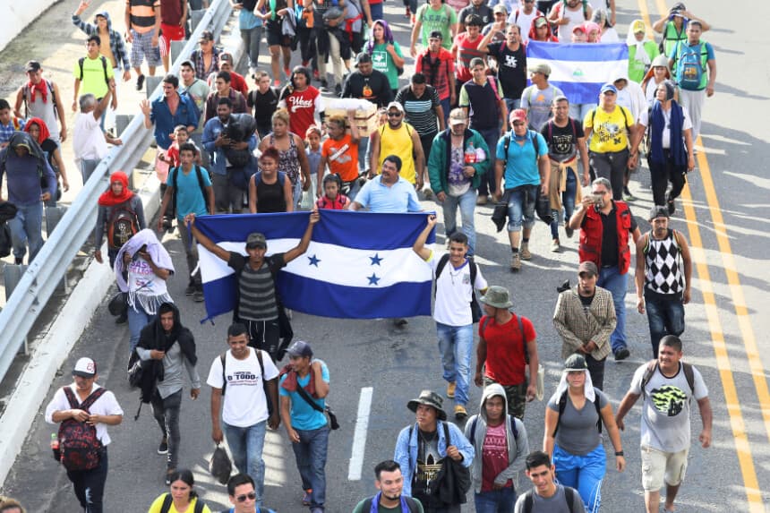 Miembros de la caravana de migrantes portan banderas de Honduras (izquierda) y Nicaragua (derecha) mientras caminan tras cruzar la frontera guatemalteca hacia México el 21 de octubre de 2018 cerca de Ciudad Hidalgo, México. (John Moore/Getty Images)