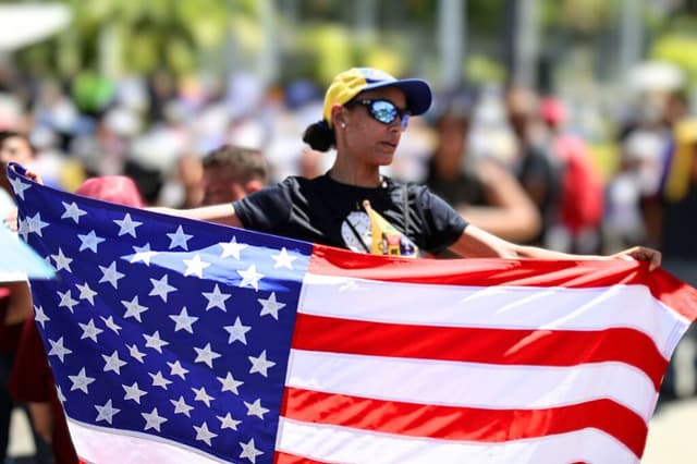 Un estudiante universitario sostiene una bandera estadounidense durante una protesta en el marco del Día de la Juventud de Venezuela, el 12 de febrero de 2026, en Caracas, Venezuela. (Jesús Vargas/Getty Images)
