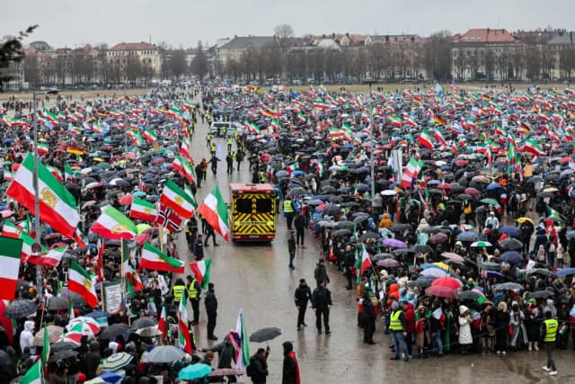Cientos de manifestantes con banderas y paraguas asisten a una manifestación de la oposición iraní el 14 de febrero de 2026 en el recinto ferial Theresienwiese de Múnich, en el sur de Alemania, al margen de la 62.ª Conferencia de Seguridad de Múnich (MSC). (Foto de Alexandra BEIER / AFP a través de Getty Images)