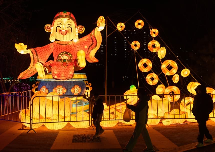 Personas caminan cerca de decoraciones relacionadas con el Año Nuevo Chino en Beijing. EFE/EPA/JESSICA LEE