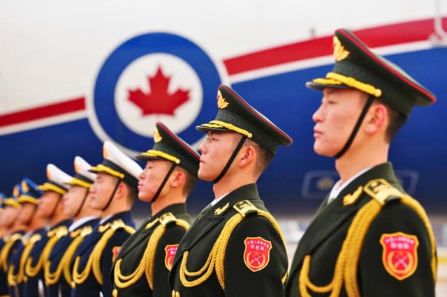 Una guardia de honor china espera la partida del primer ministro Mark Carney en el aeropuerto de Beijing, China, el 17 de enero de 2026, de camino a Doha, Qatar. (The Canadian Press/Sean Kilpatrick).