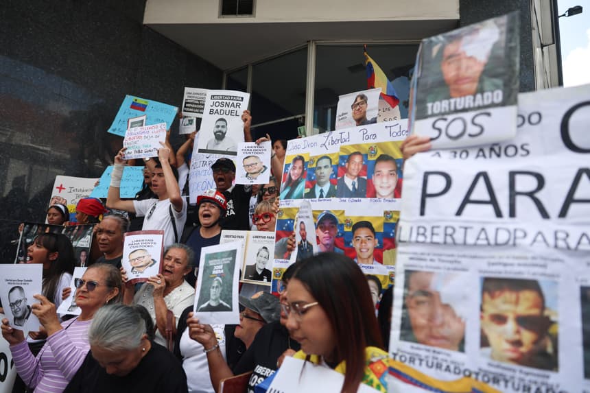 Fotografía de archivo de personas mientras sostienen carteles con imágenes de presos políticos en Caracas. Venezuela. (EFE/ Miguel Gutiérrez)