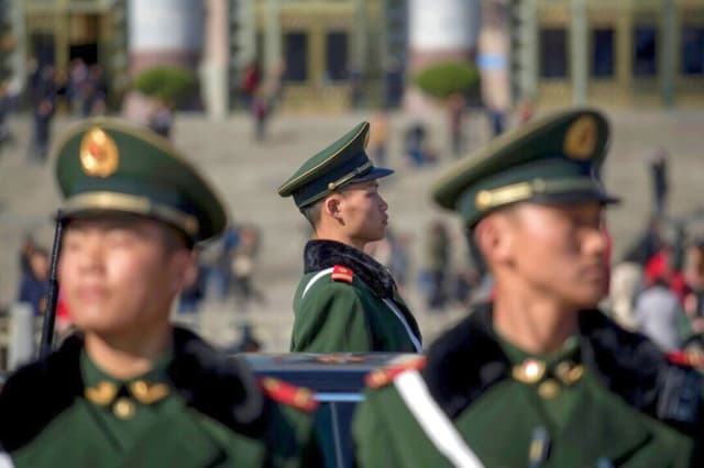 Oficiales de la policía paramilitar posan frente al Gran Salón del Pueblo durante la inauguración de la legislatura china, el Congreso Nacional del Pueblo, en Beijing, el 5 de marzo de 2017. (Fred Dufour/AFP/Getty Images).