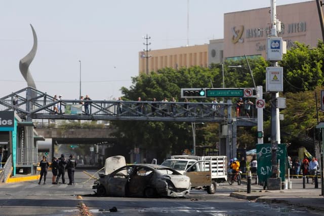 Fotografía que muestra un bloqueo con vehículos incendiados este domingo, en una vía de Guadalajara, México. (EFE/ Francisco Guasco)
