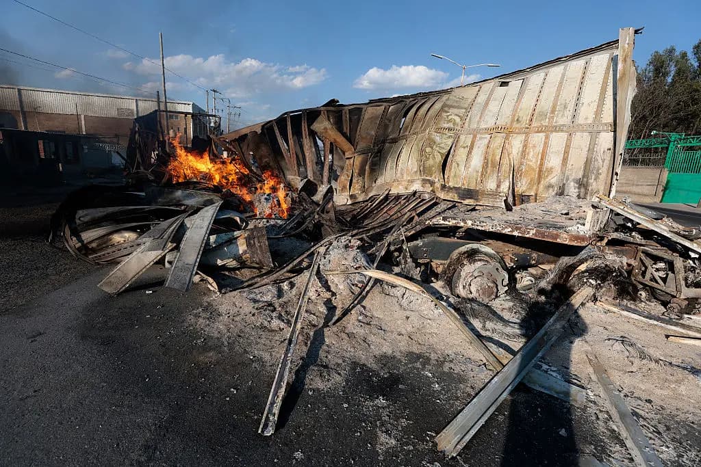 Vista de un camión en llamas, presuntamente incendiado por grupos del crimen organizado en respuesta a un operativo para detener a un objetivo de seguridad de alta prioridad, en una carretera cerca de Acatlán de Juárez, estado de Jalisco, México, el 22 de febrero de 2026. (Ulises Ruiz/AFP vía Getty Images)