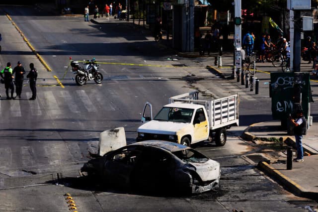Fotografía que muestra un bloqueo con vehículos incendiados este domingo, en una vía de Guadalajara. (EFE/ Francisco Guasco)