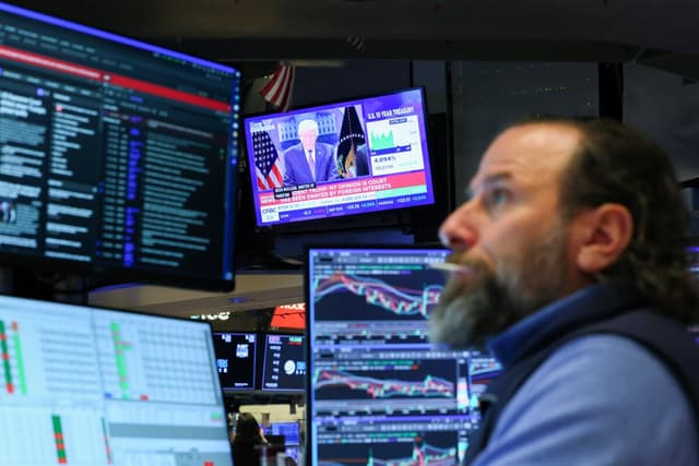 Una rueda de prensa del presidente Donald Trump sobre los aranceles se muestra en un televisor mientras los operadores trabajan en la sala de la Bolsa de Nueva York, el 20 de febrero de 2026. (Michael M. Santiago/Getty Images)