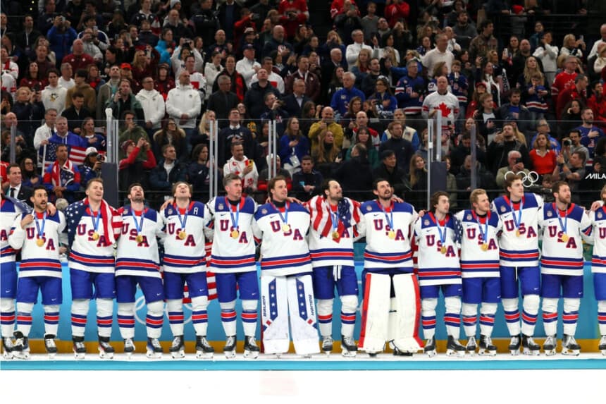 Los miembros del equipo de Estados Unidos escuchan el himno nacional durante la ceremonia de entrega de medallas de hockey sobre hielo masculino tras ganar la medalla de oro en el partido por la medalla de oro masculino entre Canadá y Estados Unidos en la jornada 16 de los Juegos Olímpicos de Invierno de Milán Cortina 2026, en el Milano Santagiulia Ice Hockey Arena de Milán, Italia, el 22 de febrero de 2026. (.Bruce Bennett/Getty Images)