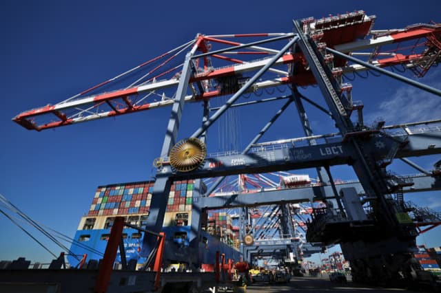 Grúas trasladan contenedores desde el buque portacontenedores Cosco Spain hasta la terminal de contenedores de Long Beach (LGCT) en el puerto de Long Beach, California, el 14 de enero de 2026. (Foto de Patrick T. Fallon / AFP a través de Getty Images).
