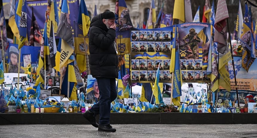 Un hombre pasa junto a un monumento a los soldados ucranianos caídos antes de la ceremonia de encendido de velas en el Monumento Nacional del Pueblo en la Plaza de la Independencia, en Kiev, Ucrania, el 24 de febrero de 2026. (Leon Neal/Getty Images)
