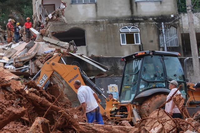 Personas observan una zona afectada por fuertes lluvias este martes, en Juiz de Fora, Brasil. (EFE/ Andre Coelho)
