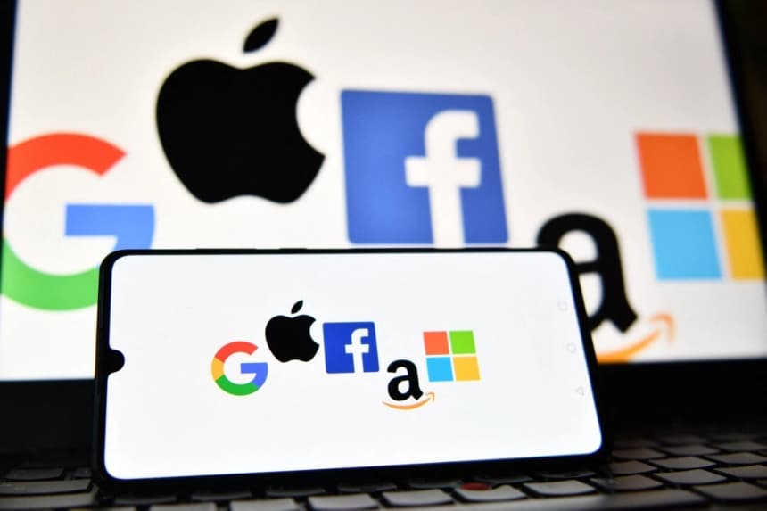 Los logotipos de Google, Apple, Facebook, Amazon y Microsoft en la pantalla de un teléfono móvil y una computadora portátil. (Justin Tallis/AFP vía Getty Images)